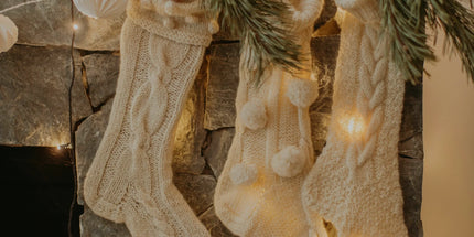 Three handmade white christmas stockings hanging over the fire