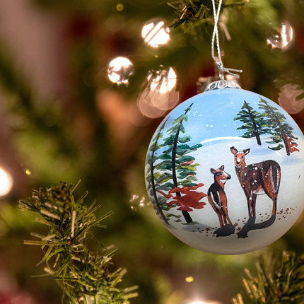 Snowman and Deer Next to a Snowy Cabin