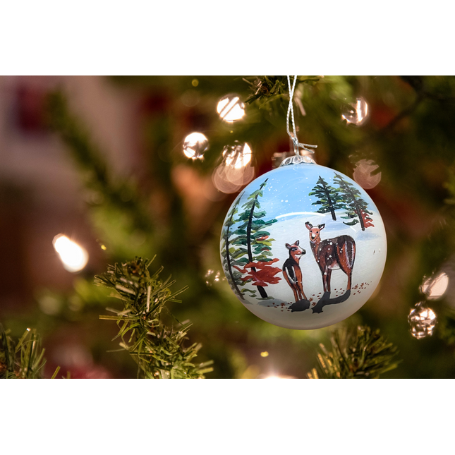 Snowman and Deer Next to a Snowy Cabin